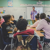 Students look at their teacher in a grade school classroom